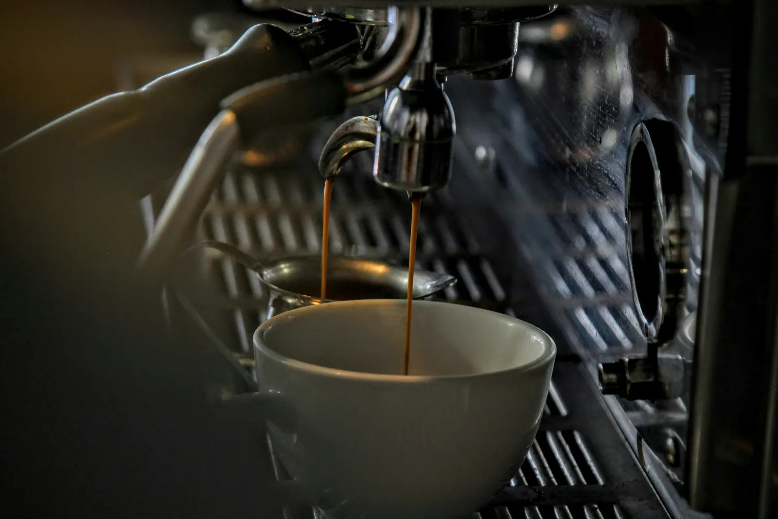Espresso läuft aus dem Siebträger einer Kaffeemaschine in eine Tasse