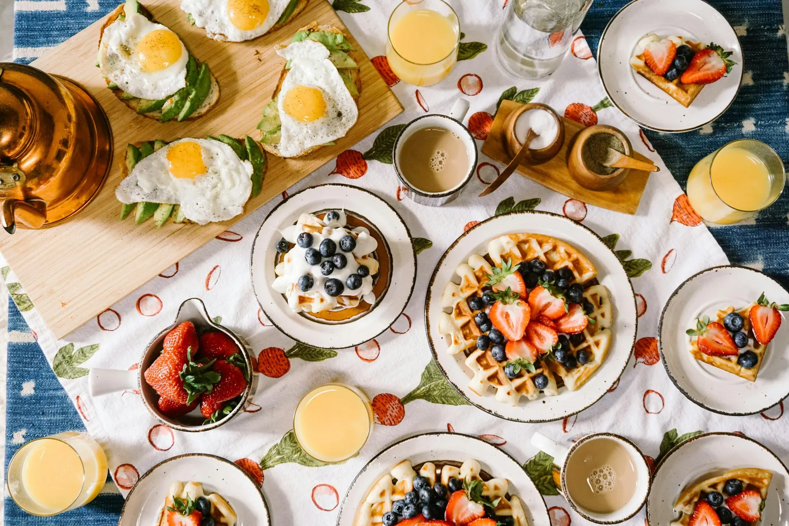 Frühstückstisch mit Waffeln, Eiern und Obst