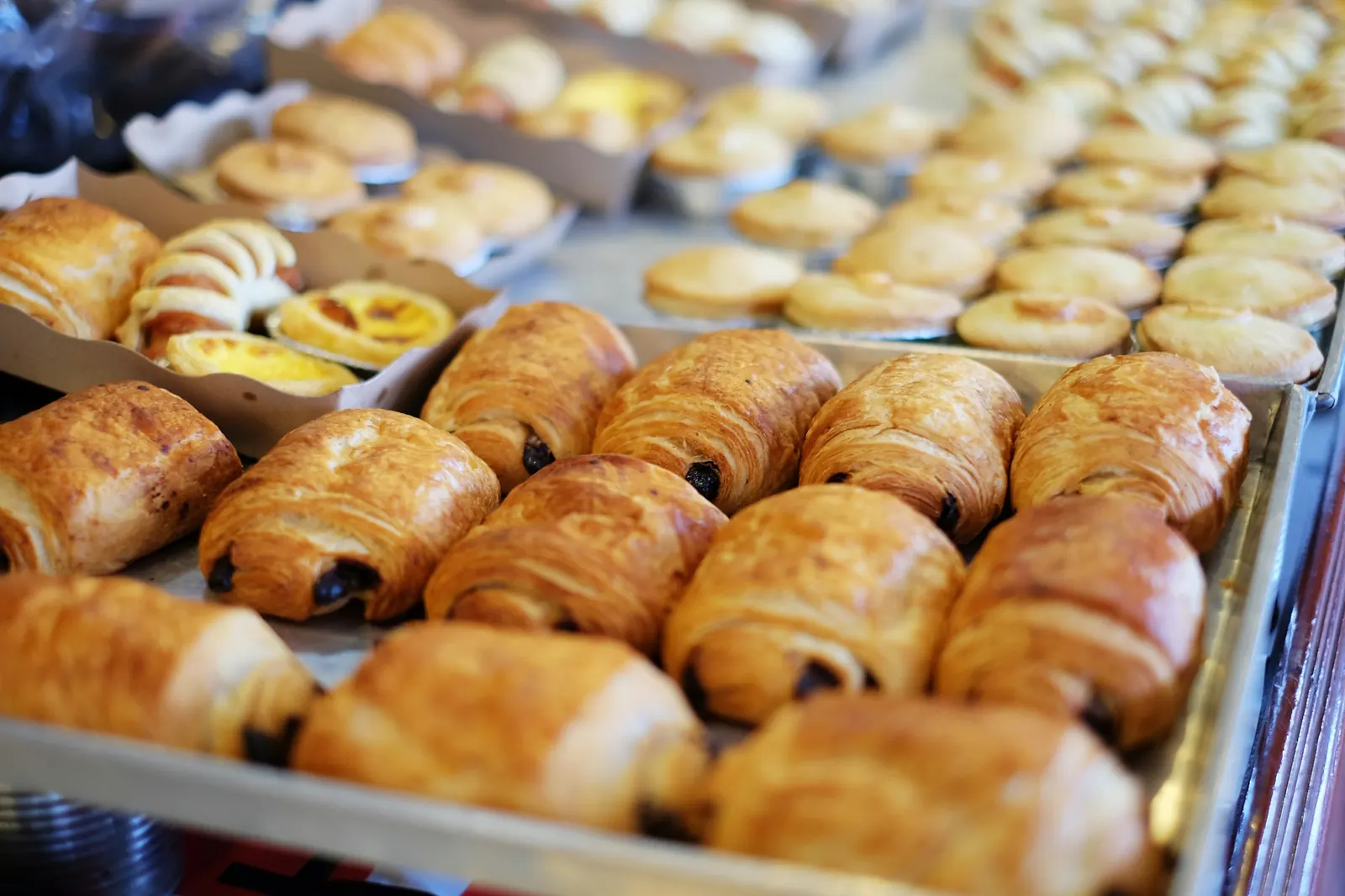 Blech voller frisch gebackener Croissants und Schokobrötchen