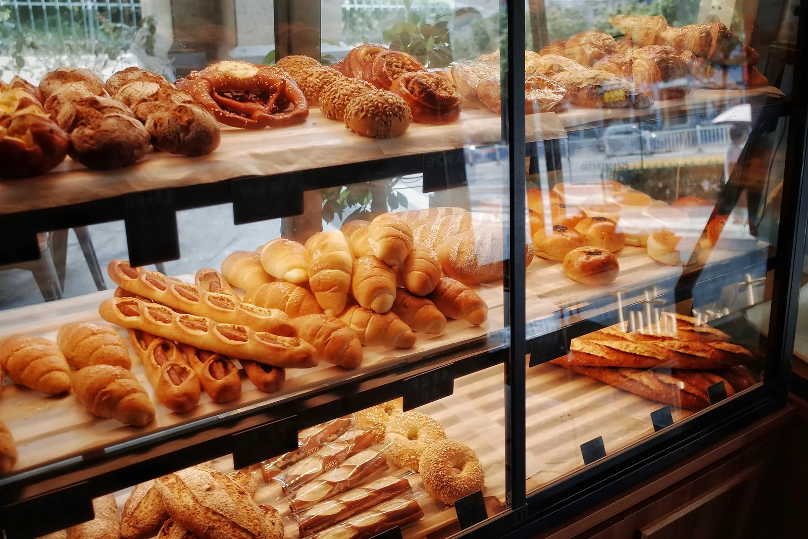 Glasvitrine voller Brote, Croissants und Gebäck