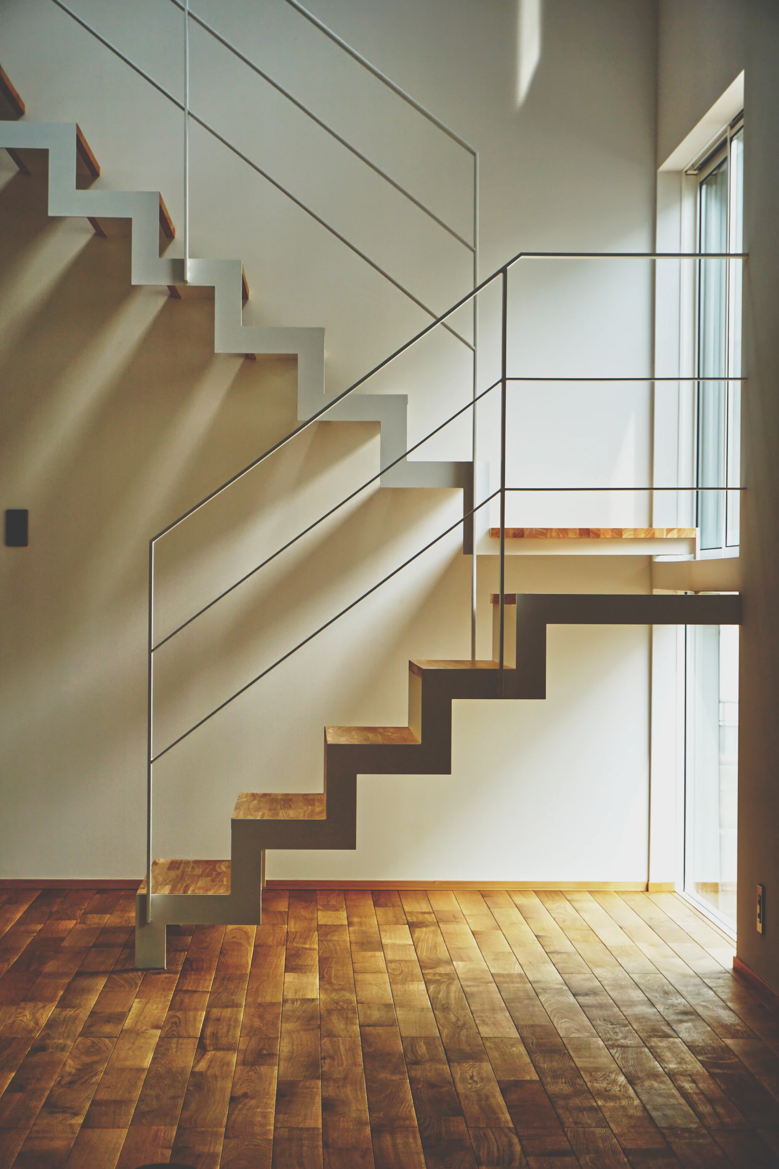 Freitragende Holztreppe vor weißer Wand
